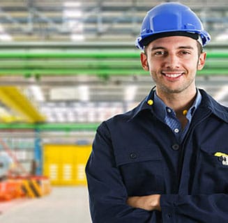 Battery recycler employee smiling in a lead battery recycling facility.