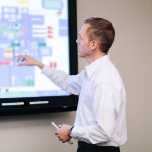Lead battery recycling employee reviewing screens for the 24-7 process control monitoring system.