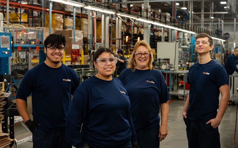 Lead battery manufacturing employees smiling at work.
