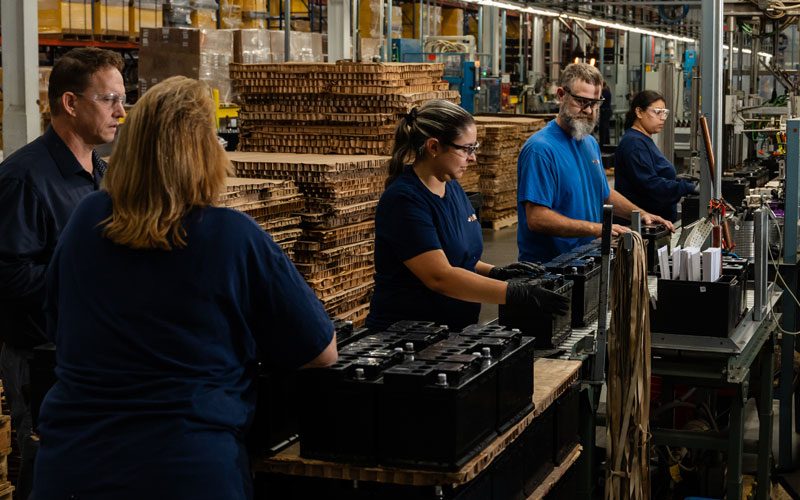Lead battery manufacturing employees working on the production line.