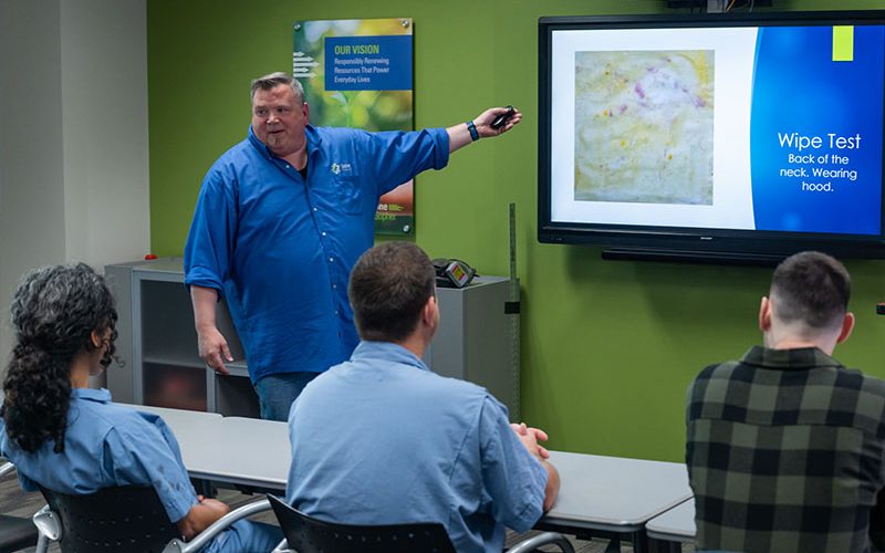 Instructor conducting employee safety training at a lead battery recycler.