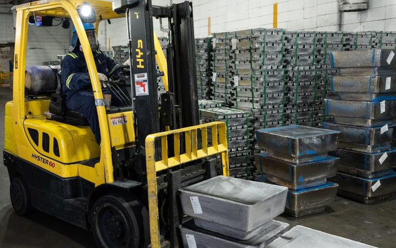 Forklift with lead ingots and stacks of recycled lead ingots to supply raw materials to manufacturers.
