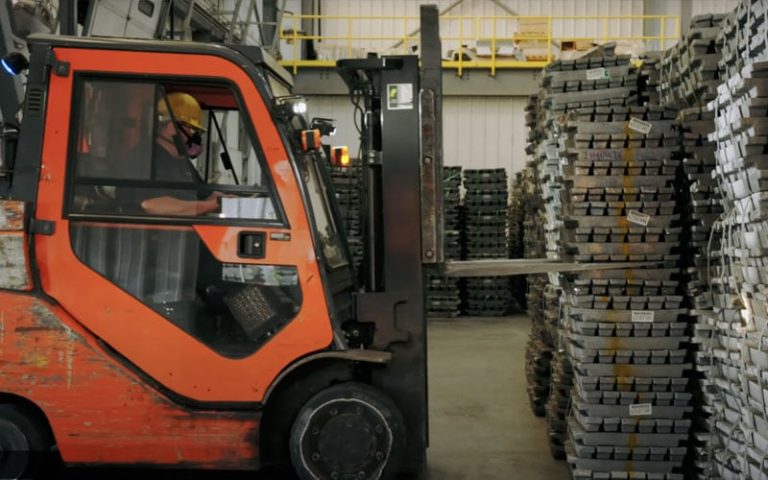 Lead battery powered forklift picking up lead ingots.