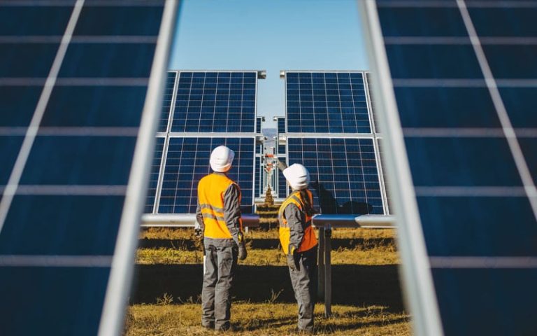 Workers at a solar farm that stores energy with sustainable lead batteries.