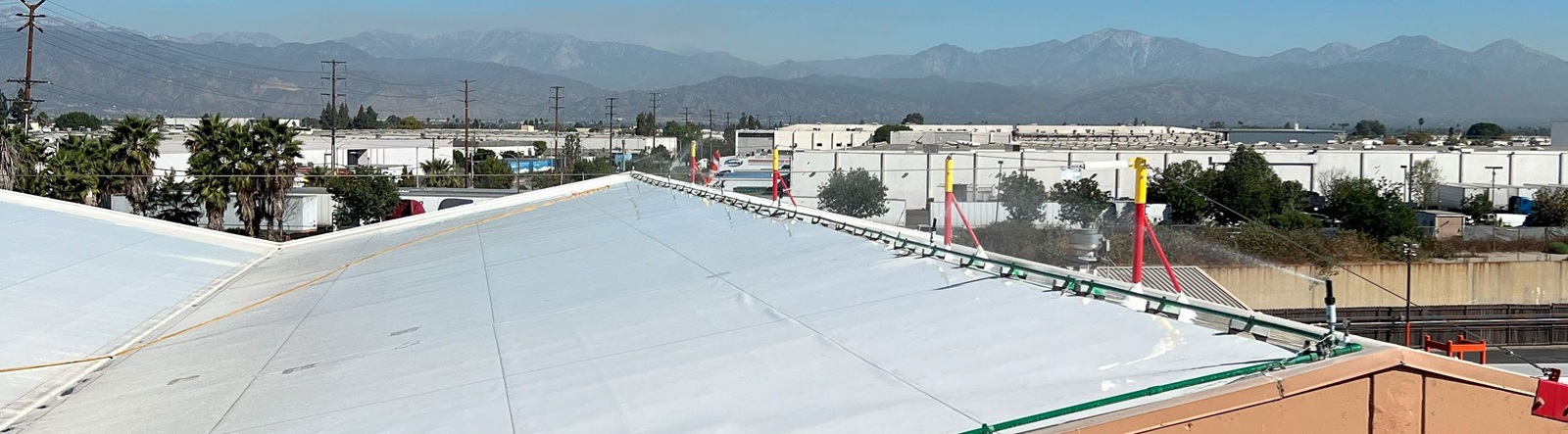 Lead battery recycling facility rooftop sprinkler to control emissions for environmental excellence.